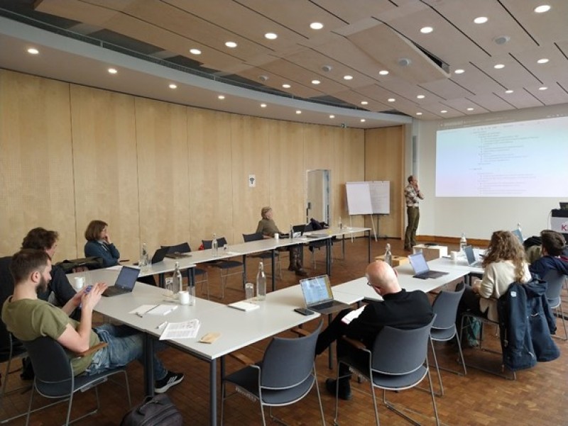 A group of people sitting at tables in a conference roomDescription automatically generated with low confidence